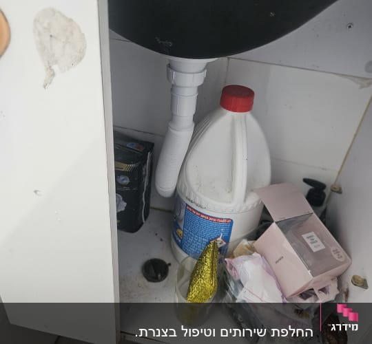 ארון מתחת לכיור עם חומרי ניקוי